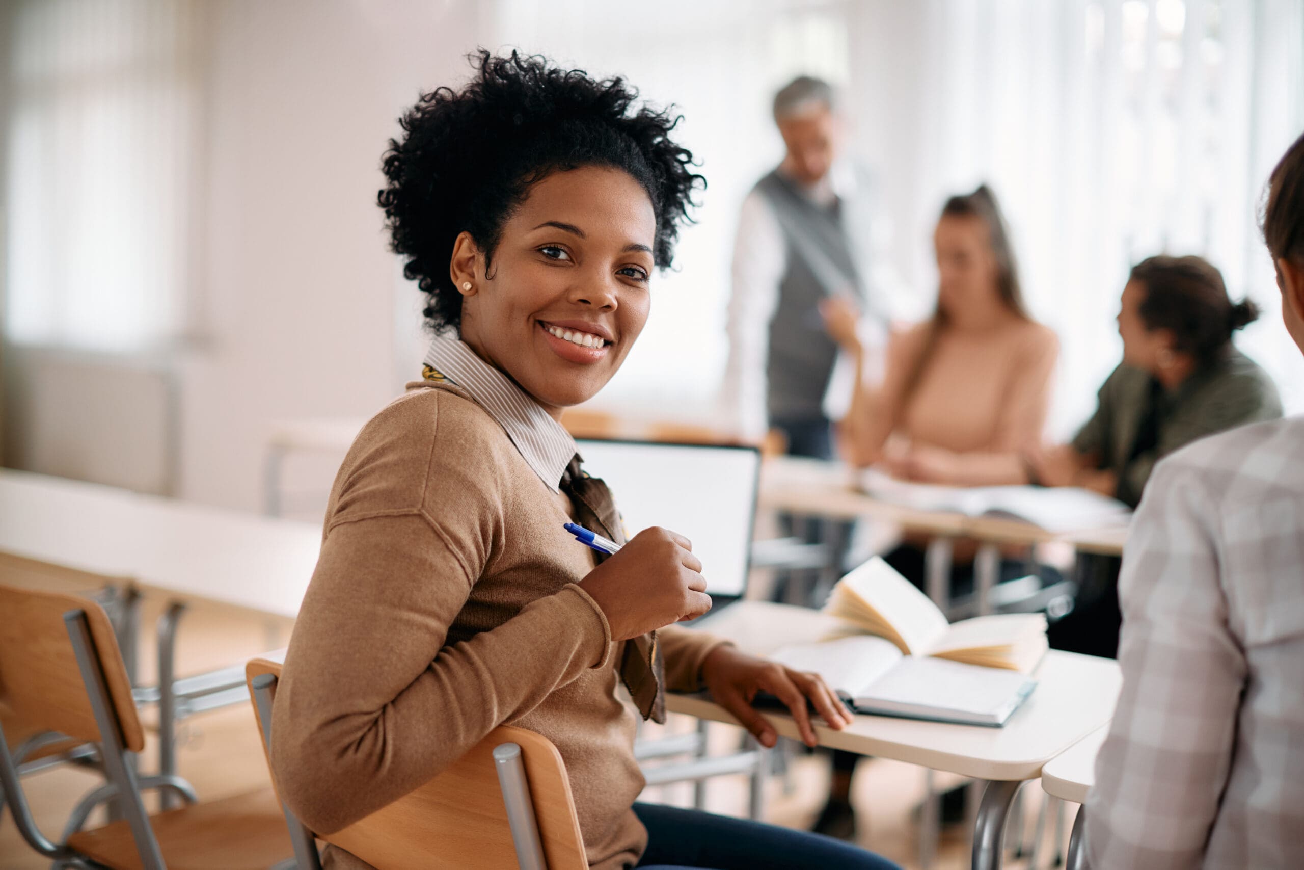 adult student sitting at desk and smiling