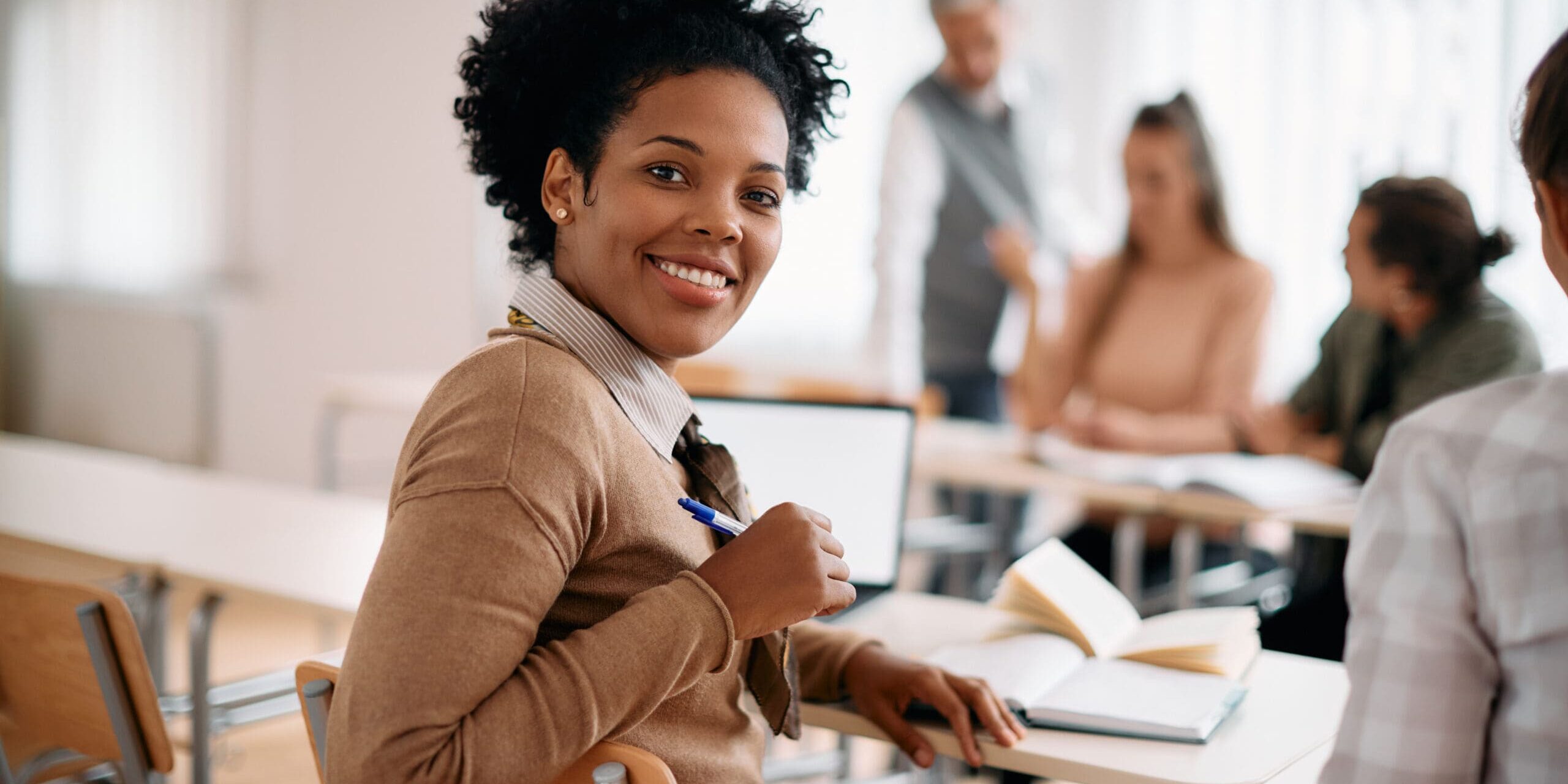 adult student sitting at desk and smiling