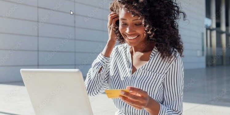 Young black college student outdoors with laptop