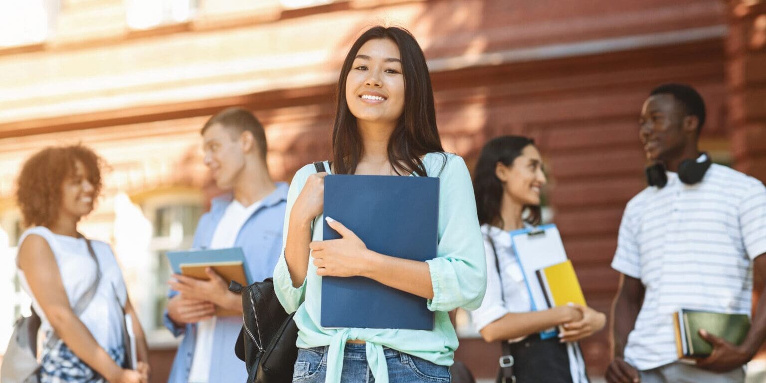 Portrait Of Happy Asian Student Girl Posing Outdoors In Campus