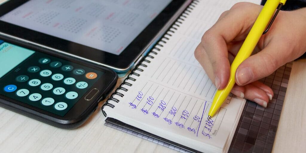 notepad with a calculator related to budgeting