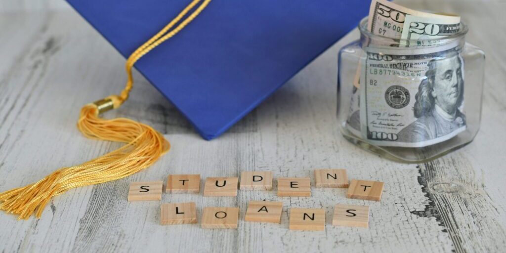 student loans written in scrabble pieces and a graduation cap